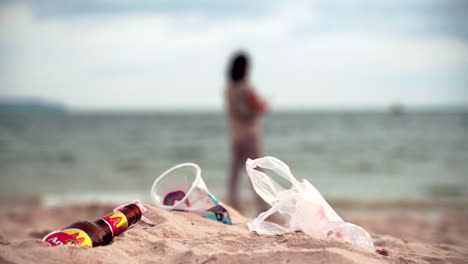 Contaminación-Plástica-Y-Una-Mujer-En-El-Fondo-De-Una-Playa-En-Sihanoukville,-Camboya