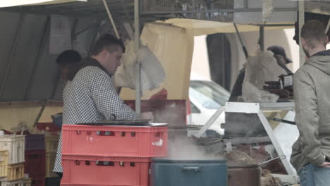 A-man-buys-street-food-from-a-local-vendor-at-the-Slavic-Carnival-in-Melnik,-Czech-Republic
