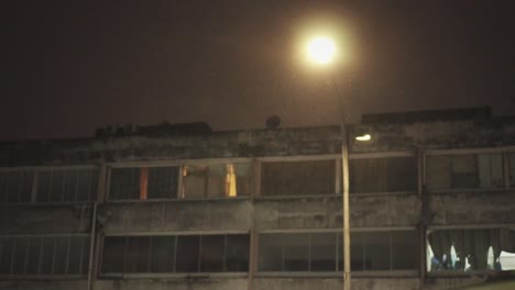 Nachts-Regnet-Es-Mit-Straßenlaterne-Und-Altem-Gebäude-Im-Hintergrund-In-Zeitlupe