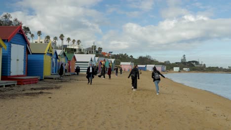 Tourists-walking-and-taking-photo-at-Brighton-Bathing-Boxes,-Melbourne,-Australia