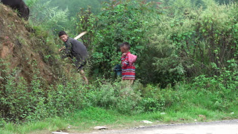 Kathmandu,-Nepal---September-27,-2019:-Two-Nepali-boys-herding-water-buffalo-in-the-mountains-around-Kathmandu,-Nepal-on-September-27,-2019