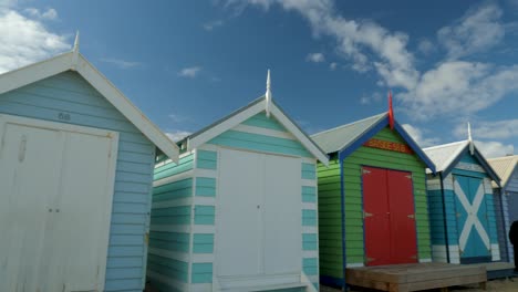 Tourists-walking-and-taking-photo-at-Brighton-Bathing-Boxes,-Melbourne,-Australia