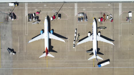 Una-Vista-De-Pájaro-De-Dos-Aviones-Mientras-La-Tripulación-De-Tierra-Se-Prepara-Para-Desembarcar-A-Los-Pasajeros