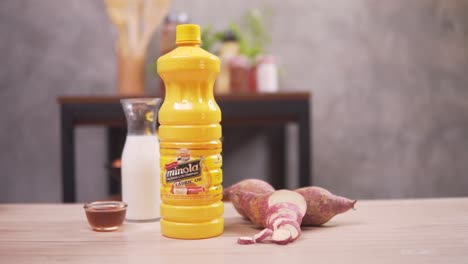 Woman-Get-The-Lauric-Oil-In-Bottle-On-The-Table,-With-Fish-Sauce,-Vinegar,-And-Sweet-Potatoes-Prepared---Closeup-Shot