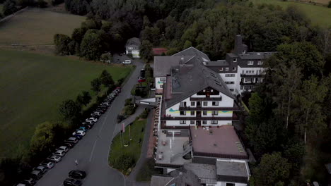 Vista-Aérea-Del-Hotel-Alpin-En-El-Balneario-Y-Pueblo-De-Esquí-De-Grafschaft-En-La-Región-De-Sauerland-Cerca-De-Winterberg-Contra-Un-Cielo-Azul-Con-Nubes