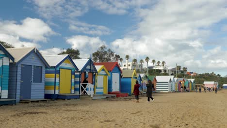 Tourists-walking-and-taking-photo-at-Brighton-Bathing-Boxes,-Melbourne,-Australia