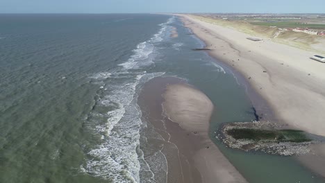 Strandwellen-In-Den-Dünen-Der-Niederlande-Und-Menschen,-Die-Am-Strand-Spazieren-Gehen,-Drohnenansicht