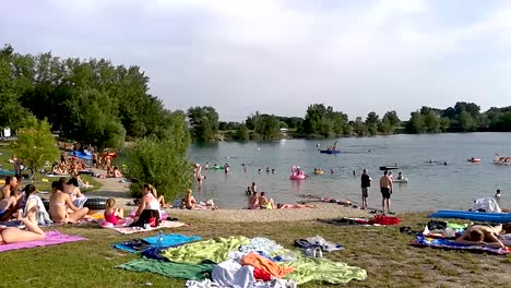 Panning-view-of-people-having-a-good-time-by-the-lake-on-the-hot-summer-day