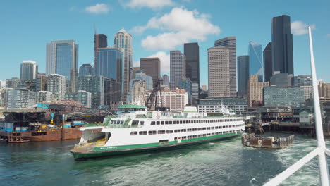 Blick-Auf-Pier-52-Und-Die-Innenstadt-Von-Seattle-Vom-Wasser-An-Bord-Der-Washington-State-Ferry,-Die-Colman-Dock-Verlässt,-Während-Eine-Andere-Fähre-Ankommt