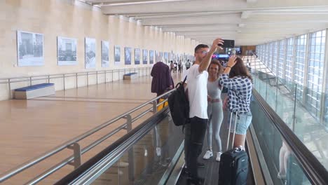 Tourists-taking-a-selfie-on-a-moving-walkway-in-transit-on-Ben-Gurion-airport,-Israel