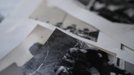 A-close-up-shot-of-old,-black-and-white-portrait-photographs-of-people-from-the-80s,-laid-out-on-a-table-together