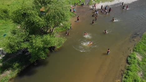 Luftaufnahme-Von-Menschen,-Die-In-Einem-Schlammigen-Fluss-In-Bulgarien-Schwimmen