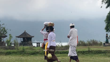 Gruppe-Asiatischer-Leute,-Die-Zu-Einer-Zeremonie-Im-Ulun-Danu-Bratan-Tempel-In-Bali,-Indonesien,-Gehen