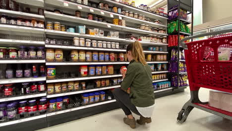 Woman-selects-her-favorite-peanut-butter-and-puts-it-in-cart-at-Target