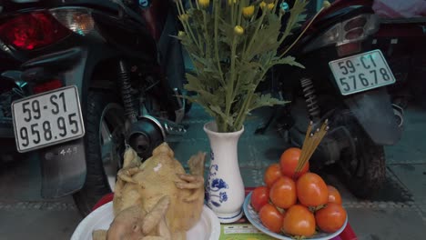 Buddhist-monthly-offereng-of-food,-incense-and-flowers-in-the-doorway-of-a-business-in-Vietnam