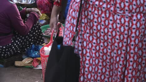 Young-Lady-Selecting-a-Chicken-to-Buy-in-a-Busy-Market