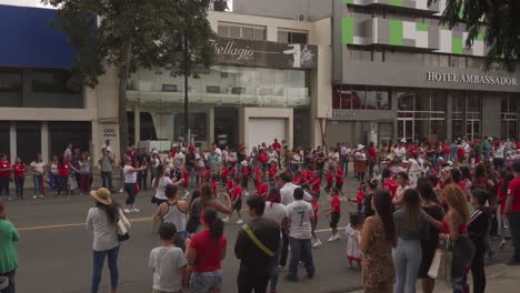 Menschenmenge-Beobachtet,-Wie-Kleine-Kinder-Während-Der-Parade-Zum-Unabhängigkeitstag-Von-Costa-Rica-Mit-Hula-Hoop-Reifen-Auftreten