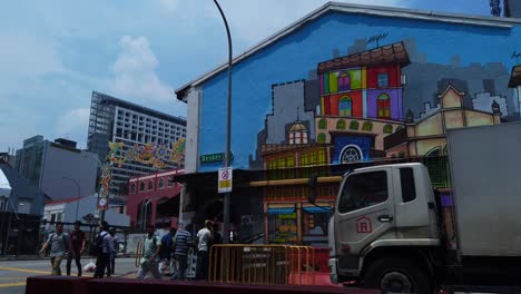 Un-Arte-Colorido-Pintado-En-La-Pared-Con-Señales-De-Zona-De-Control-De-Bebidas-Alcohólicas-En-Esta-Concurrida-Calle,-Gente-Caminando-Y-Otros-Edificios-Y-Carreteras-En-El-Fondo