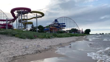 Vista-De-Los-Toboganes-De-Agua-De-Cedar-Point-Y-La-Vista-De-La-Montaña-Rusa-Con-Un-Espectacular-Cielo-Nublado-De-Fondo-Desde-La-Playa-De-La-Costa-De-Cedar-Point---Orillas-Del-Lago-Erie