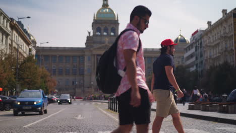 Dolly-side-shot-showing,-two-tourists-passing-the-wenceslas-square-on-sunny-day-in-Prague