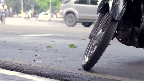 Stadtverkehrskonzept-Parkplatz-Motorrad,-Roller-Detail-Im-Vordergrund-Leichte-Autos-Im-Verschwommenen-Hintergrund