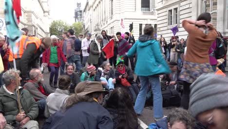 Los-Manifestantes-Se-Sientan-En-El-Suelo-Y-Cantan-Canciones-Durante-Las-Protestas-De-Rebelión-De-Extinción-En-Londres,-Reino-Unido.