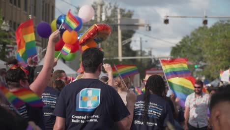Slow-Motion-Shot-of-People-Marching-in-Street-With-Pride-Flags-at-River-City-Pride-Parade-in-Jacksonville,-FL