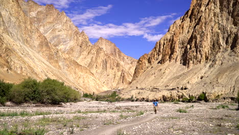 Un-Hombre-Caminando-Hacia-La-Cámara,-Espectacular-Vista-Al-Aire-Libre-Con-Una-Cordillera-Del-Himalaya-En-El-Fondo