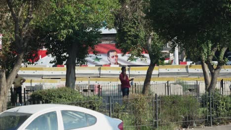 Daily-life-in-Damascus,-Syria,-people-on-the-streets-and-on-the-phone,-Syrian-flags-in-the-background