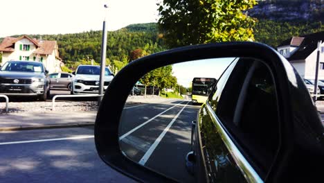 Car-running-on-the-road-while-Austrian-yellow-bus-is-following-it-and-other-on-coming-vehicles-in-the-other-lanes