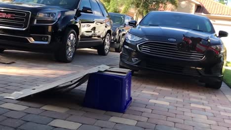 Elderly-adult-playing-with-his-grandsons-toys-in-the-driveway,-slow-motion