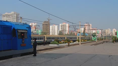 Two-men-talk-on-a-platform-while-a-train-drives-past