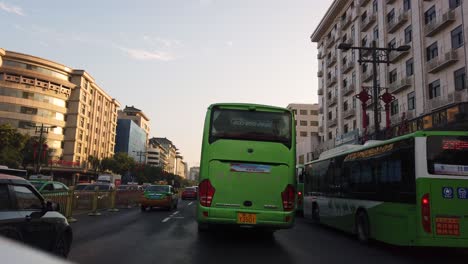 Xian,-China---July-2019-:-Car-front-view-of-the-green-bus-and-traffic-on-busy-street-in-the-city-of-Xian-in-summer,-Shaanxi-Province,-central-China