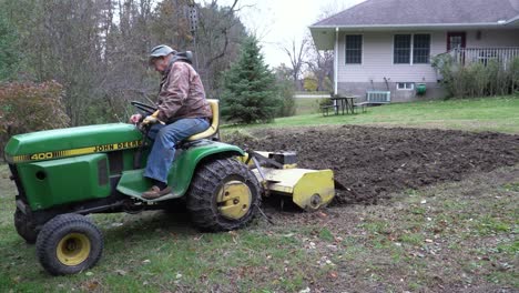A-man-uses-a-tractor-rototiller-in-the-garden-just-before-winter