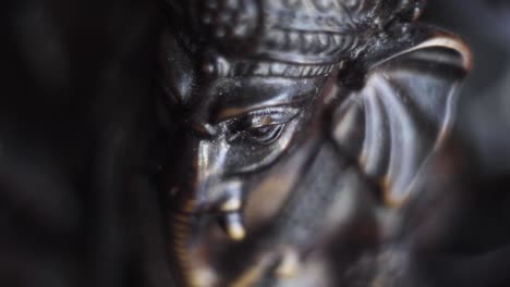 Close-up-shot-of-Ganesha-figurine-with-incense-stick-burning-on-background