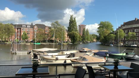 Amsterdam-boats-at-pier-dock-by-cafe-tables