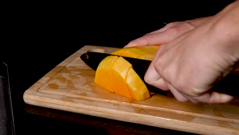 Locked-Off-View-Butternut-Pumpkin-Being-Sliced-And-Diced-On-Wooden-Chopping-Board