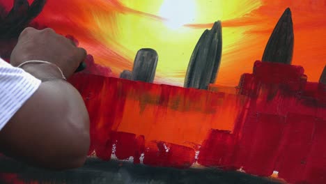 Close-Shot-of-a-Painter-Painting-Angkor-Wat-at-Sunset