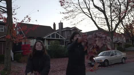 Friends-Enjoyed-Showering-Dried-Maple-Leaves-In-The-Streets-Of-Vancouver-At-Fall-On-A-Late-Afternoon---Wide-Shot