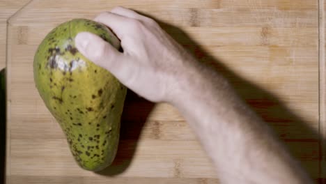 Top-down-view-of-slicing-of-an-avocado-fruit-into-half-revealing-the-inner-core-heart