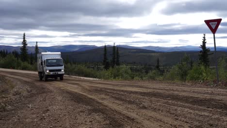 Toma-Estática-De-Un-Gran-Mitsubishi-Fuso-Conduciendo-Hacia-La-Cámara-A-Lo-Largo-De-Un-Camino-De-Tierra-En-La-Región-Del-Yukón-De-Alaska,-Ee.uu.