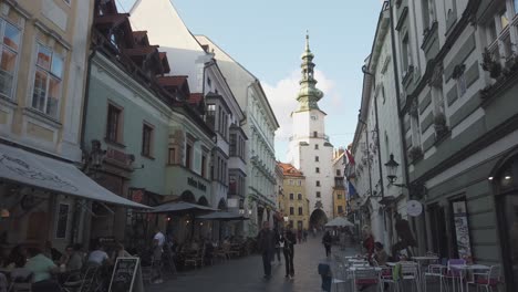 Pedestrians-on-Michalska-street-with-Michael's-Gate-in-Bratislava