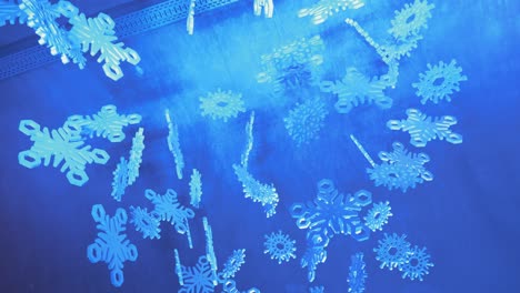 Decorative-Snow-Flakes-Hanging-From-Ceiling,-LOW-ANGLE,-Gric-tunnel