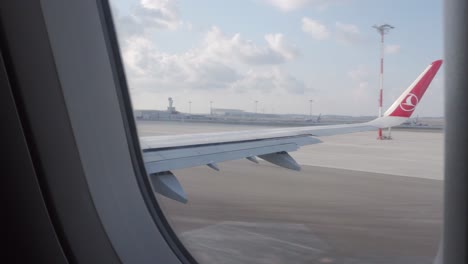 Turkish-airline-plane-accelerating,-going-for-takeoff---view-on-airport-from-window