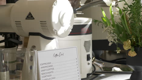 Schwenkansicht-In-Einem-Café-Mit-Kaffeebohnen,-Ausrüstung-Und-Einer-Getränkekarte-Mit-Preisen