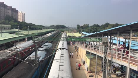 Estación-De-Tren-En-India-Con-Gente-Esperando-Mientras-El-Tren-Se-Acerca-A-La-Estación