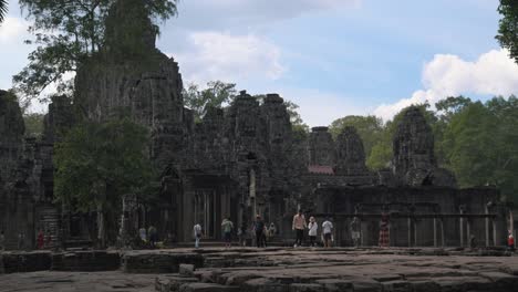Amplia-Toma-De-Tiempo-Exterior-Fuera-Del-Antiguo-Templo-Con-Turistas-Caminando-Y-El-Movimiento-De-Las-Nubes-Cerca-De-Angkor-Wat