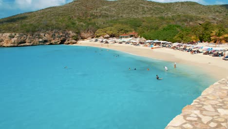 Tourist-Woman-Enjoy-Taking-Pictures-On-The-Tropical-White-Sand-Beach-with-Blue-Water-In-Grote-Knip-Beach,-Curacao---Close-Up-Shot