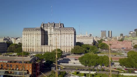 Aerial-rising-over-Sarmiento-Frigate,-Libertador-building-and-Casa-Rosada-on-background