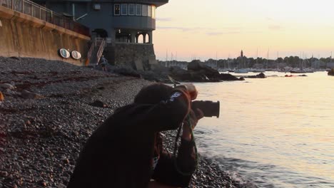 Junger-Erwachsener-Mann,-Der-Bei-Sonnenuntergang-Fotos-Am-Strand-Macht,-Stationärer-Handheld